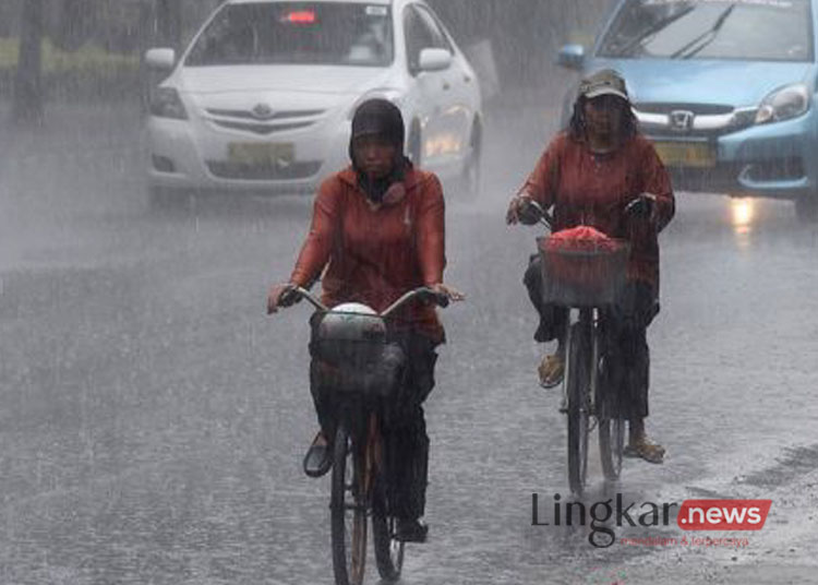 Dua orang pesepeda menembus hujan lebat di jalan Merdeka Selatan Jakarta
