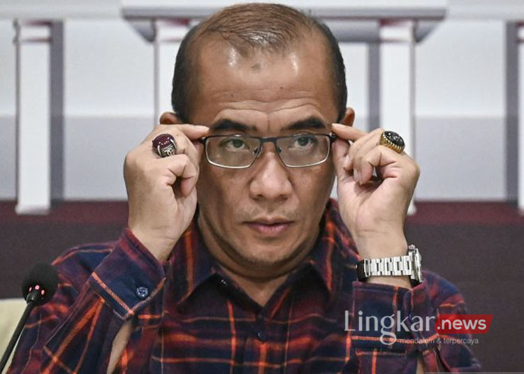 Ketua KPU Hasyim Asyari membetulkan posisi kacamata